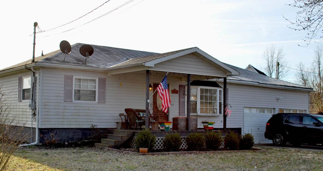 Before: one-story house with with faded siding