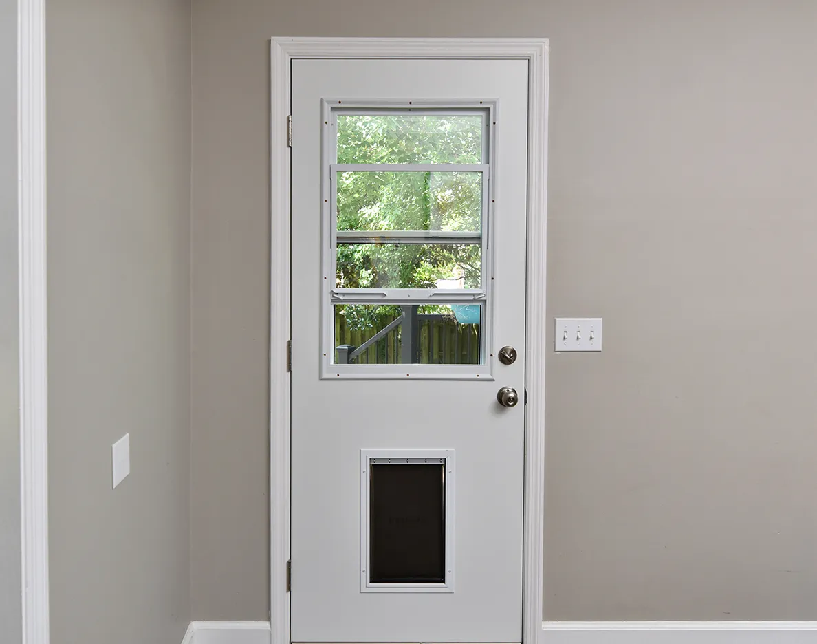 Interior view: white screen door with a pet door.