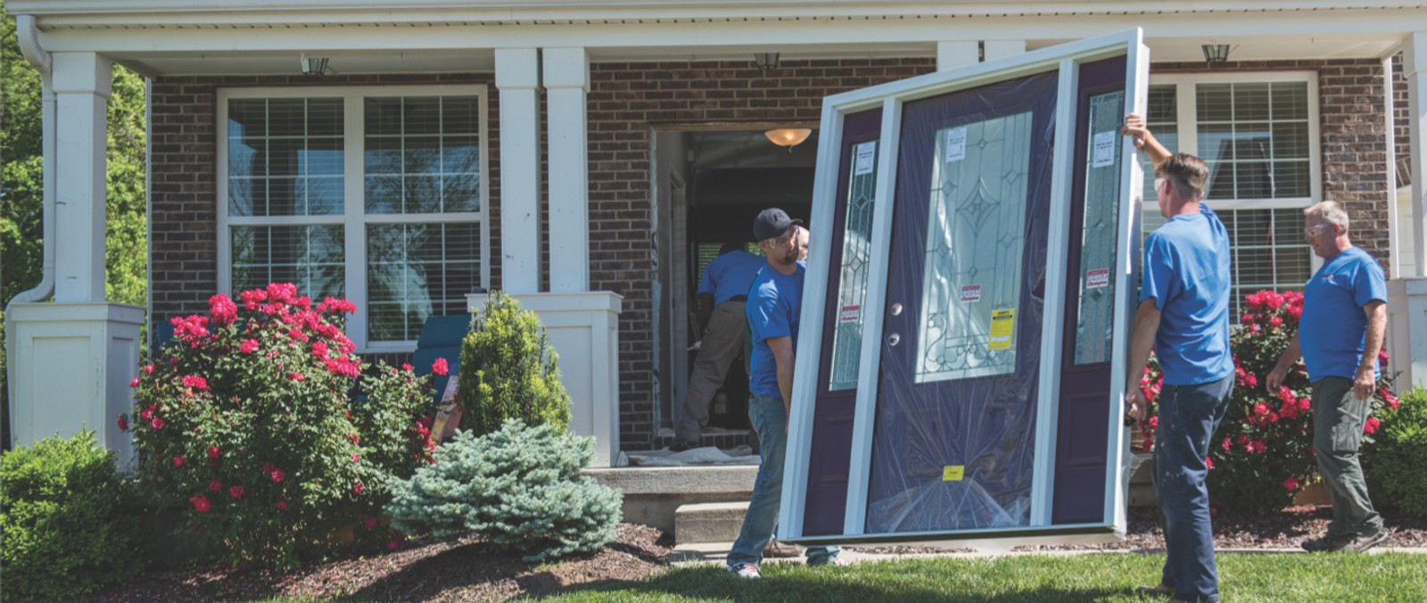 Champion installers carrying door to be installed