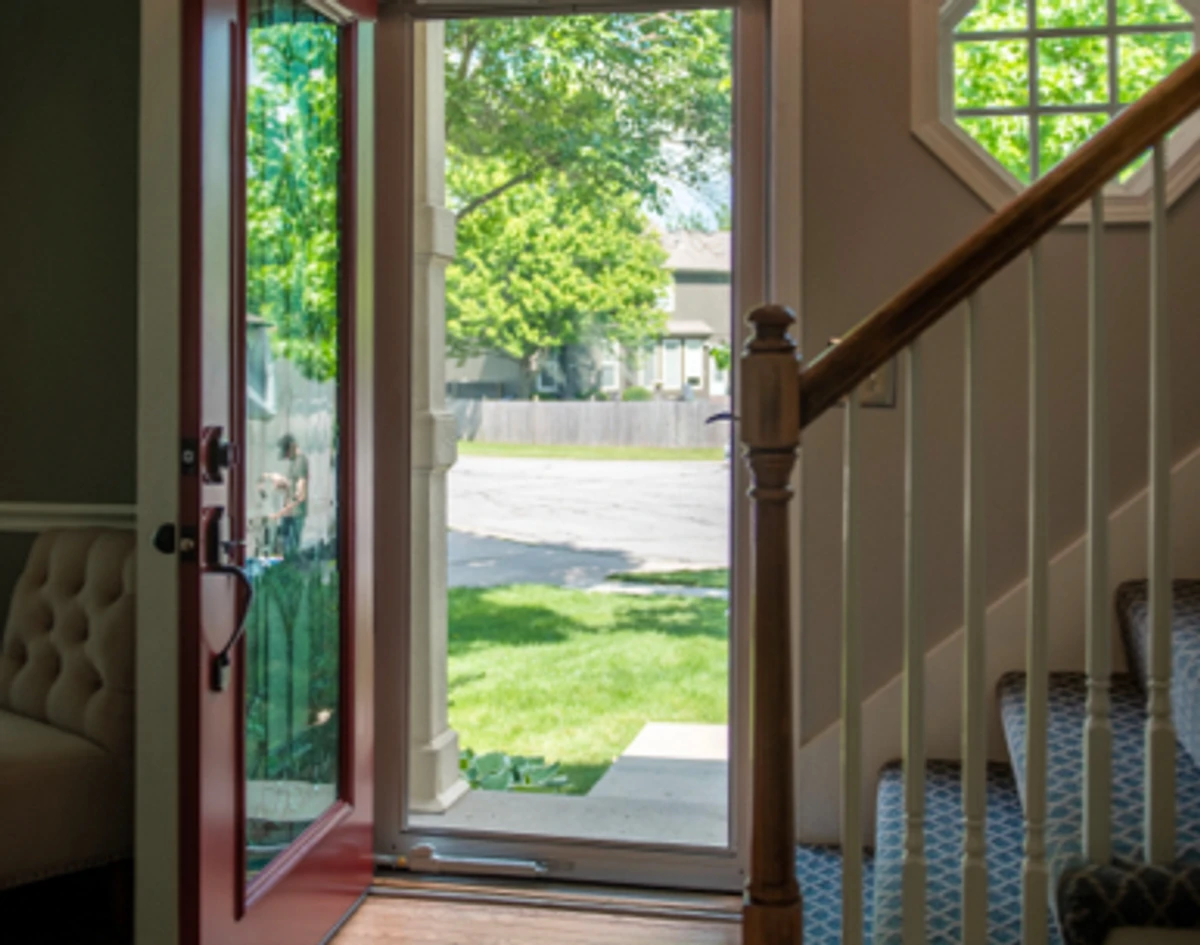 Interior view: red door open with the storm door closed.