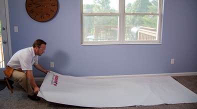 Champion installer putting down drop cloths in front of window