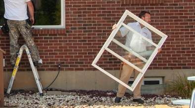 Champion installer removing old window frame from home