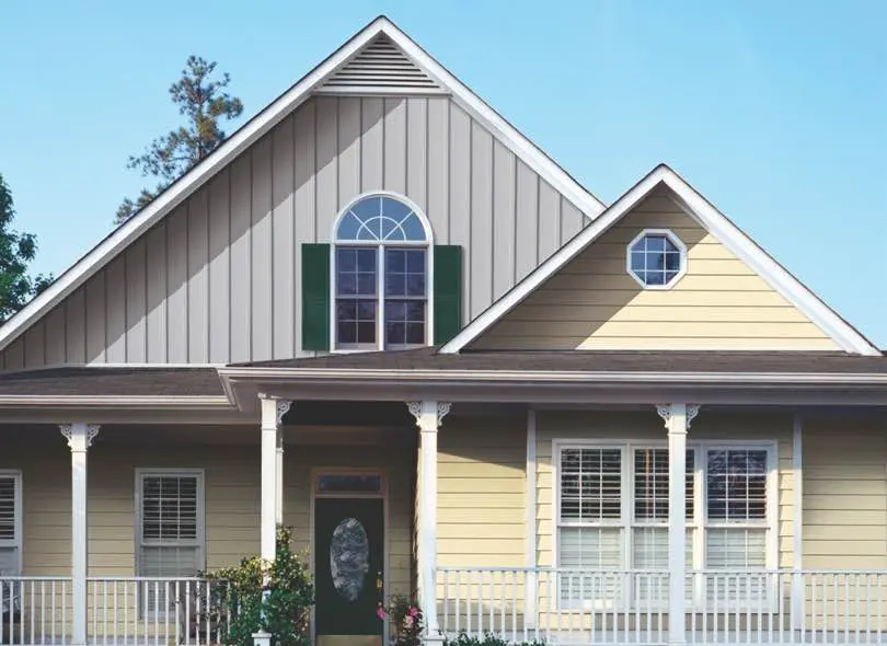 House with yellow siding and gray board and batton clapboard