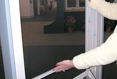 Person grabbing top and bottom of window screen