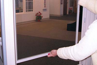 Person reinserting window screen into window