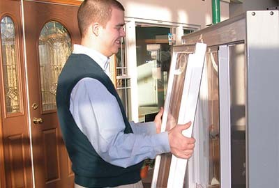 Person pulling sliding window out of window frame