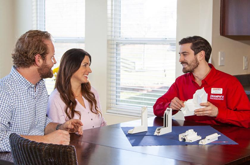 Champion employee reviewing window frame options with homeowners